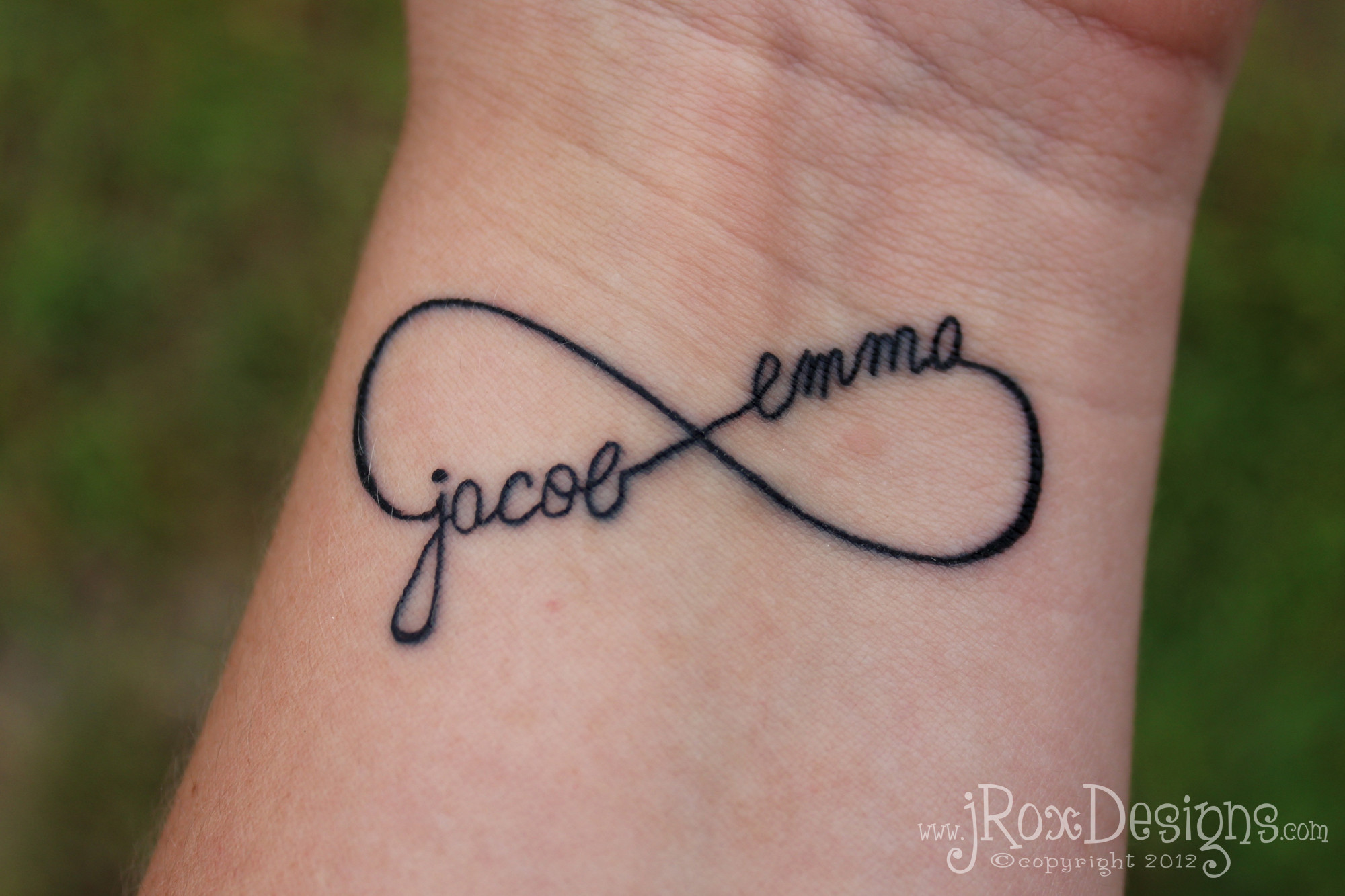 Handwritten names incorporated into infinity tattoo design, showcasing a unique and personal touch