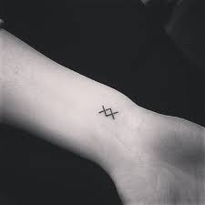 Inguz symbol tattoo on hand, small and simple design.