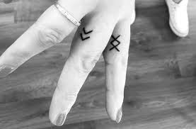 Inguz symbol tattoo on hand, representing determination and inner strength