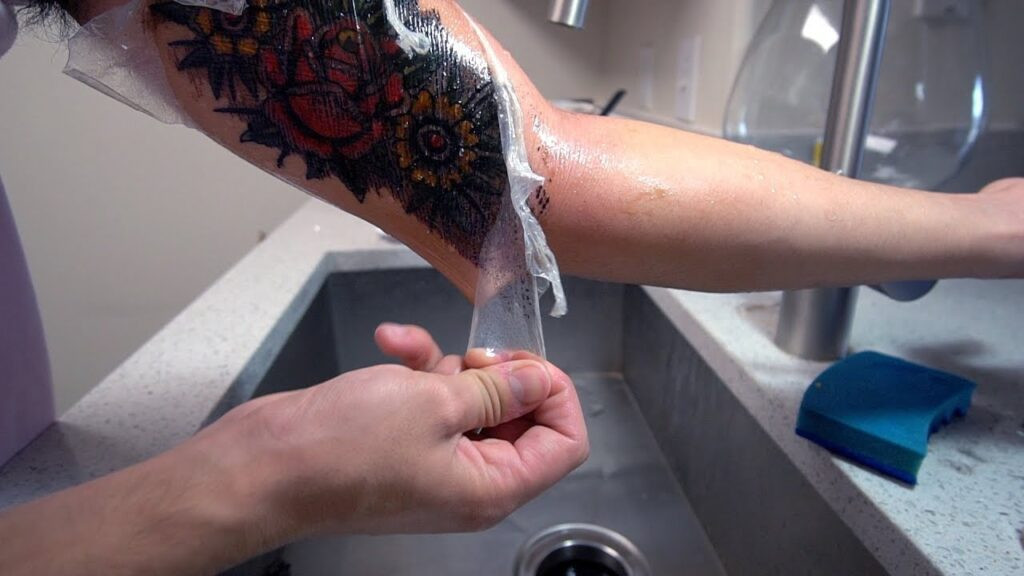 Saniderm bandage in action, protecting a new tattoo from water exposure.