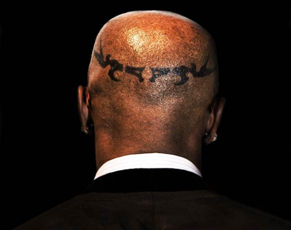 Jamie Foxx showcasing his head tattoo with thick black lines in a tribal pattern.