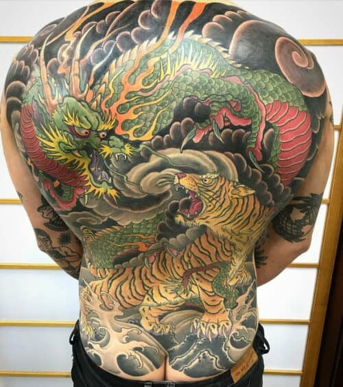 Japanese back tattoo depicting a mythical battle scene with vibrant colors