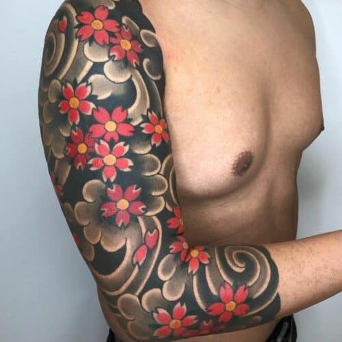 Delicate Japanese cherry blossom tattoo in pink and grey on forearm