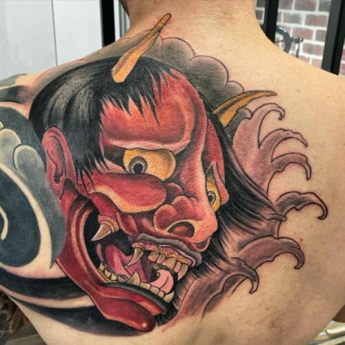 Japanese demon tattoo with a fierce oni mask in red and black