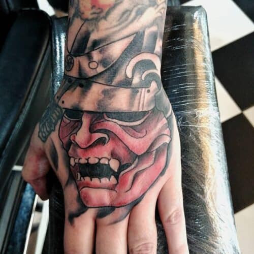 Japanese hand tattoo featuring a samurai warrior with helmet and sword