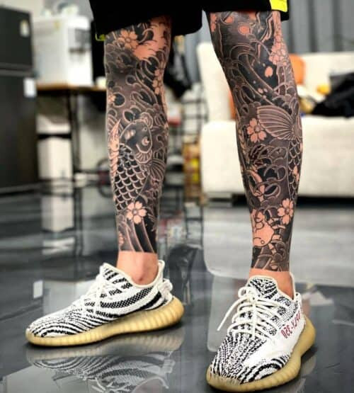 Colorful Japanese koi fish tattoo swimming upwards in a water current