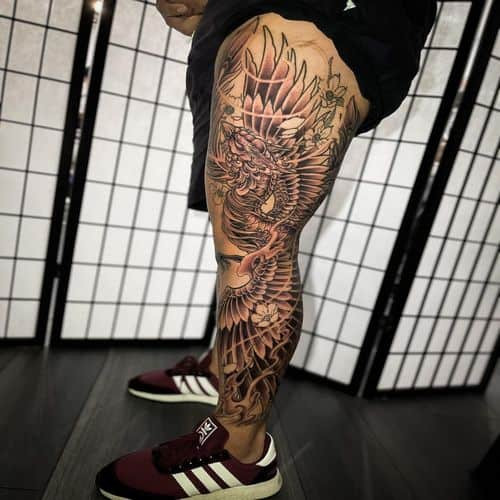 Japanese leg tattoo featuring a dragon, waves, and cherry blossoms