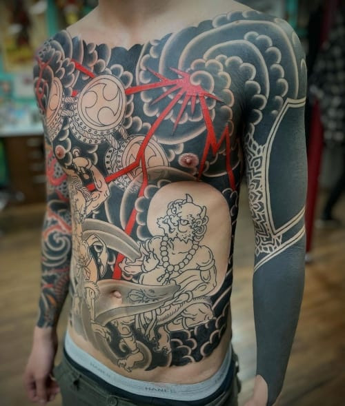 Two japanese tattoos on men, one on the forearm with a Japanese dragon and cherry blossoms and another on the arm with a Japanese Koi fish design.