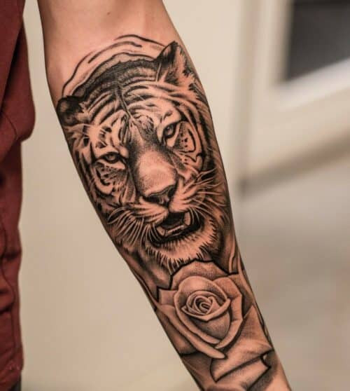 Bold Japanese tiger tattoo in black and orange with traditional wave background