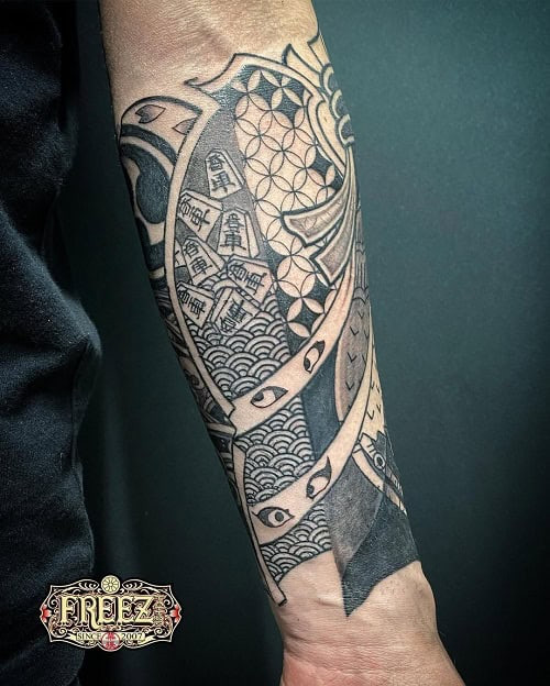 Japanese tribal tattoo on a man's arm, blending traditional Japanese motifs with tribal design elements.