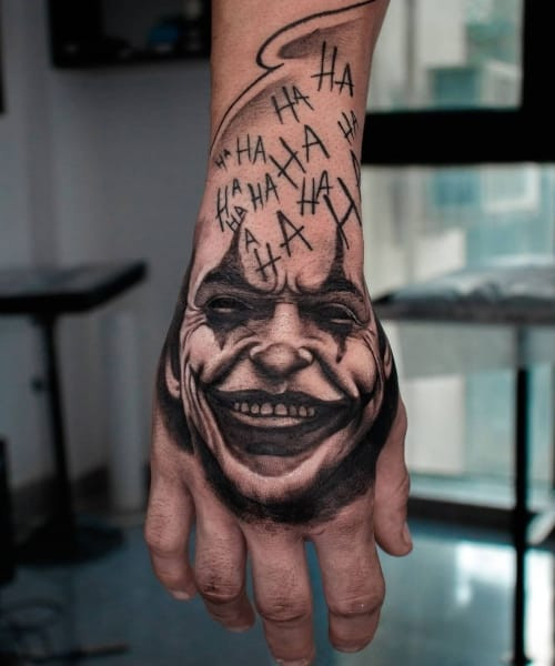 A Joker card tattoo with playing card elements on a man's leg, representing wild card