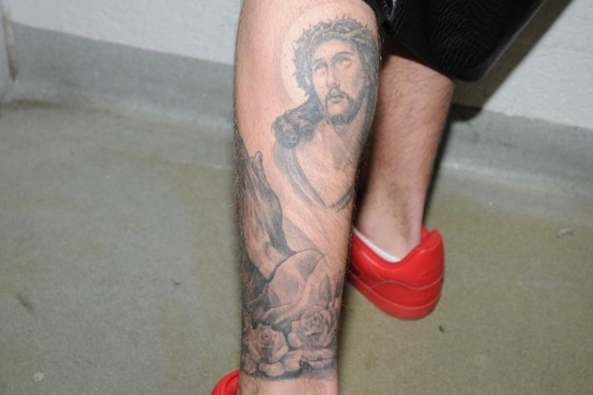 Justin Bieber leg tattoo of Jesus Christ and praying hands, showcasing his religious beliefs.