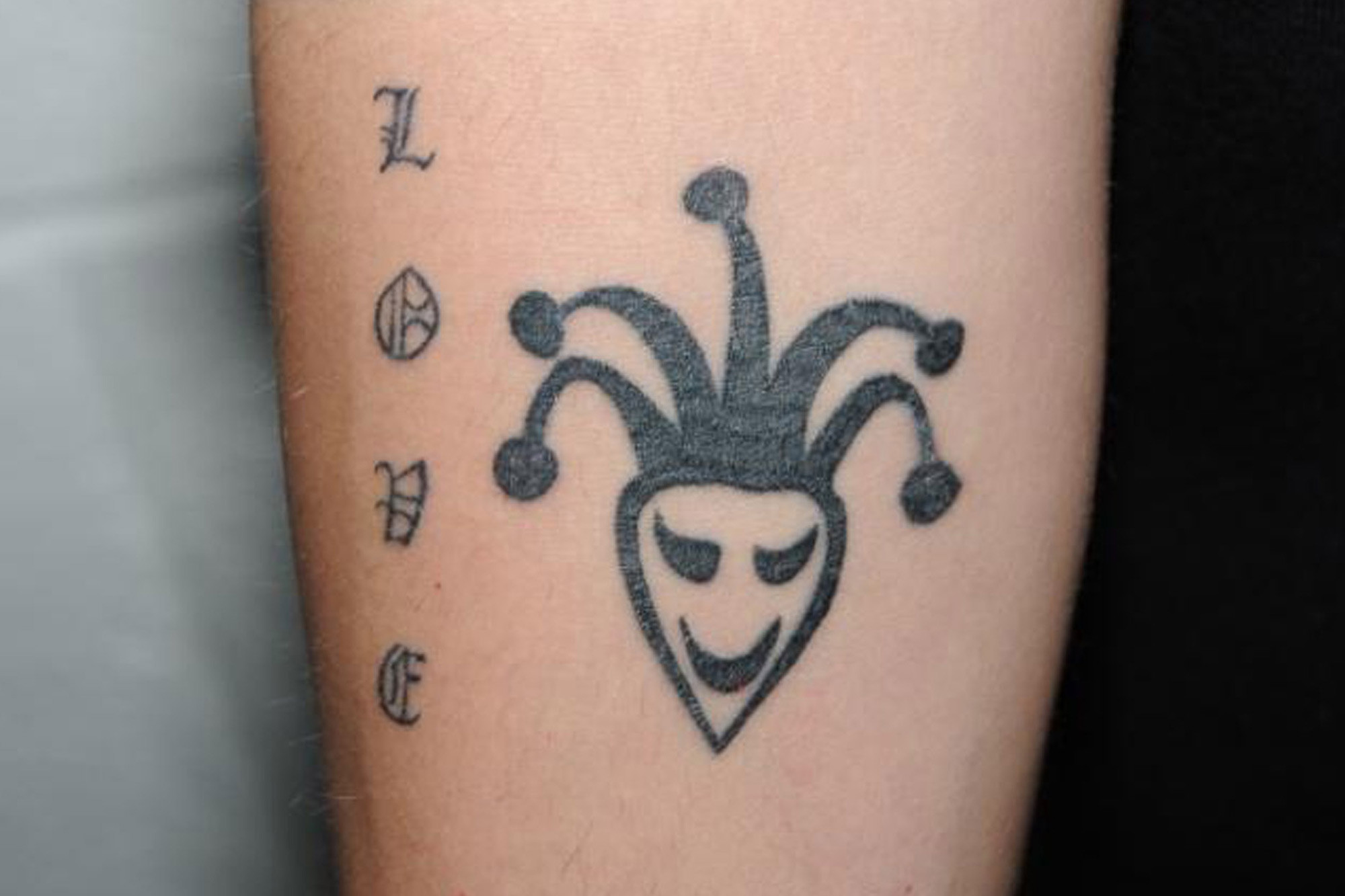 Detailed view of Justin Bieber's arm tattoo featuring a jester with makeup.