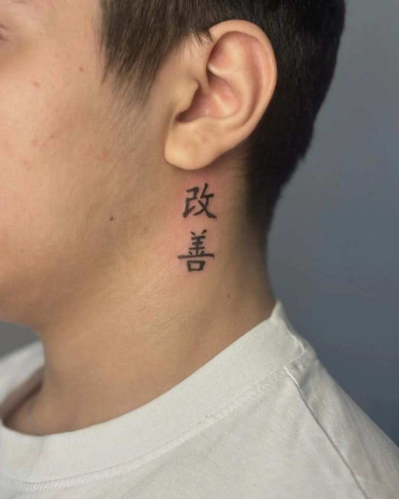 Creative negative space Kaizen tattoo using the skin as part of the design to emphasize growth and change
