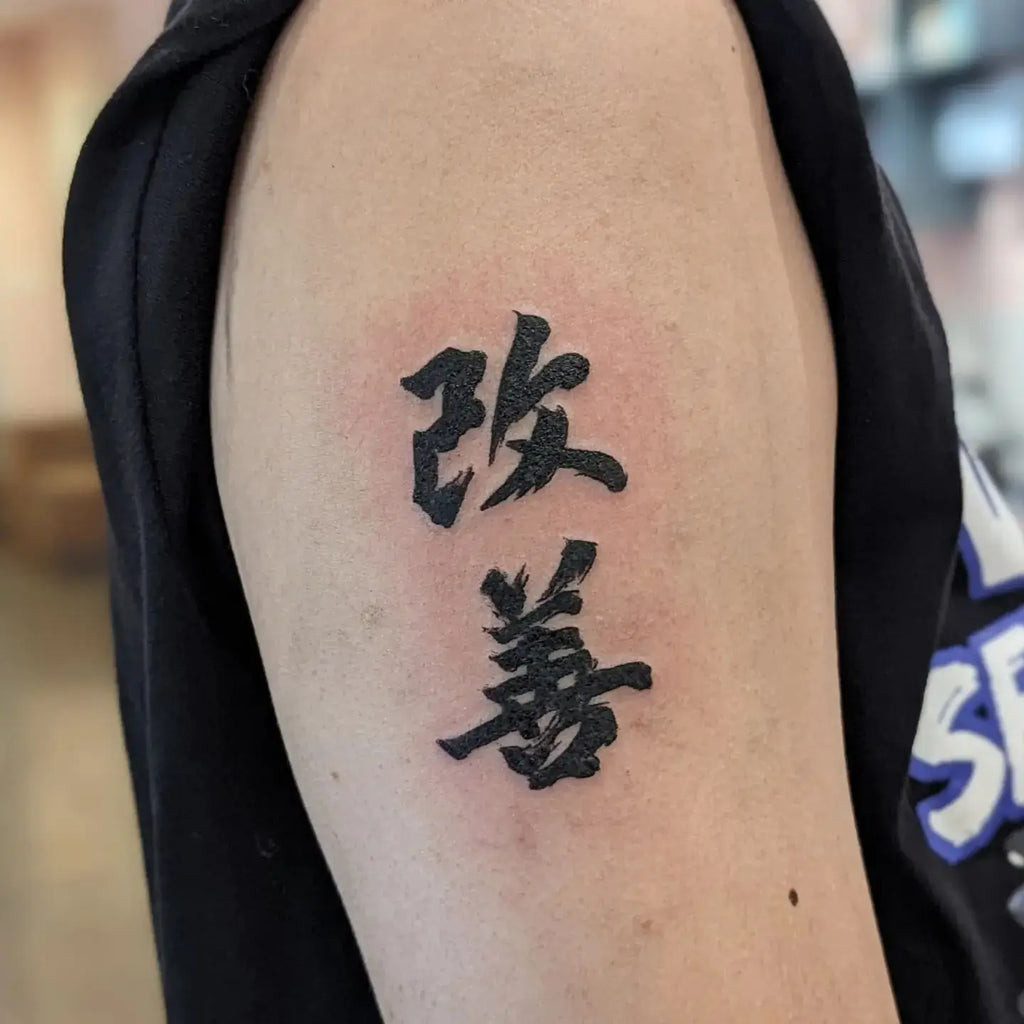 Stylized Kaizen tattoo with bold lines and shading, creating a strong and impactful visual representation of self-improvement