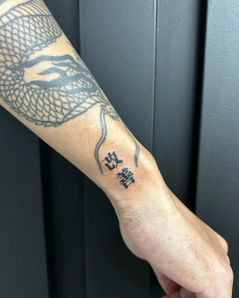 Kaizen tattoo incorporating the philosophy title in elegant script, directly stating the commitment to continuous improvement