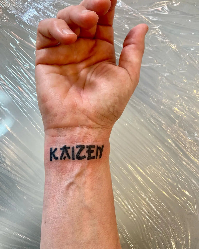 Detailed blackwork Kaizen tattoo with a phoenix rising from ashes, symbolizing rebirth and constant self-renewal