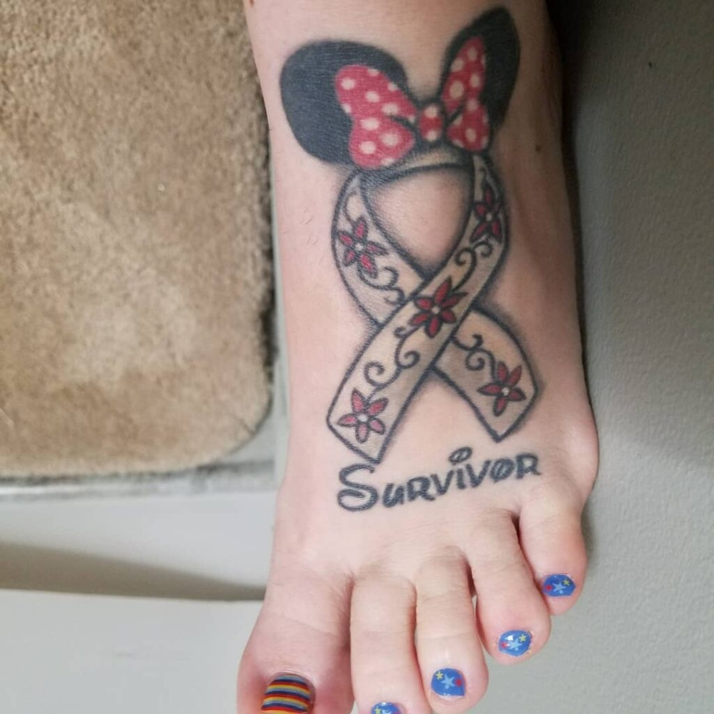 A Disney-inspired tattoo with gray ribbon, red and white flowers, and bow, signifying family, survival, and joy.