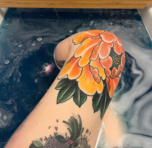 Detailed peony tattoo on knee area