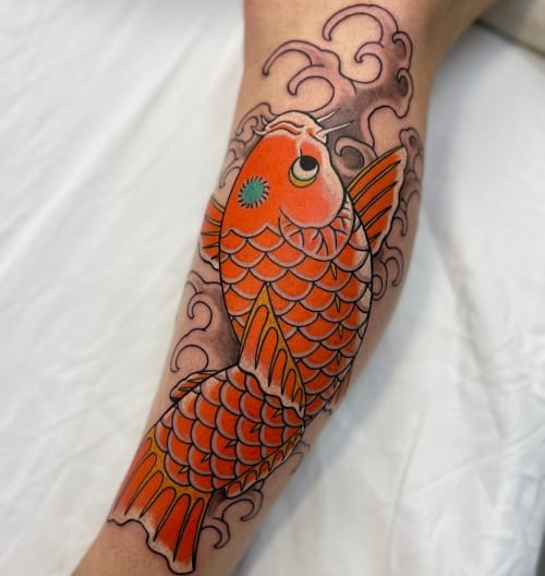 Black and grey koi fish tattoo with waves on a man's leg