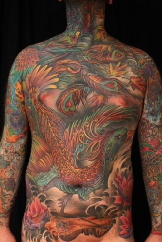 Full torso view of Kris's evolving bodysuit tattoo, showcasing the integration of Japanese motifs and vibrant colors