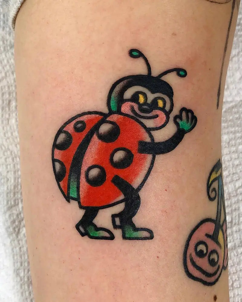 A ladybug tattoo combined with floral elements, representing nature and growth, created by Rafaelkendi