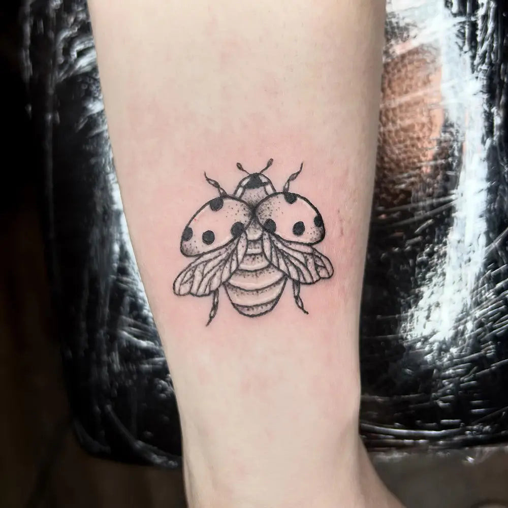 An abstract style ladybug tattoo, using shapes and lines for artistic expression, created by Janvrink