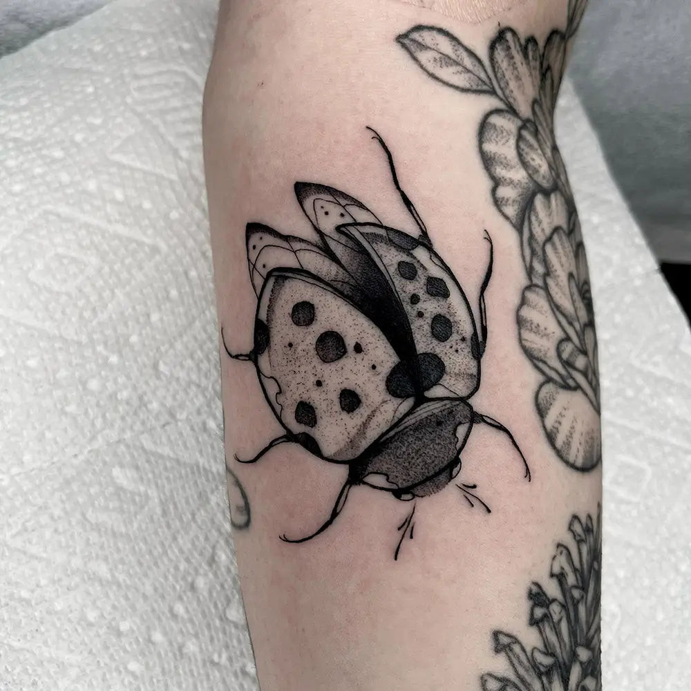 A ladybug tattoo prominently placed on the wrist, serving as a daily reminder, created by Reese_cote