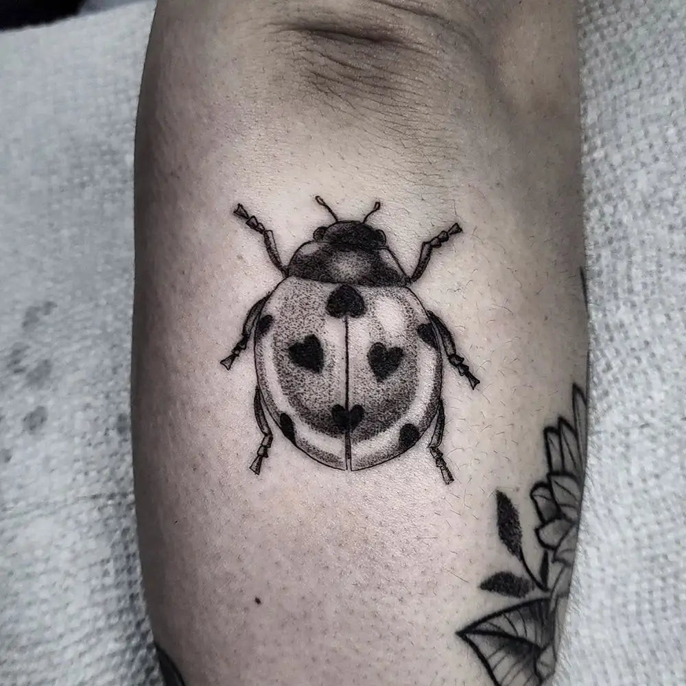 A ladybug tattoo on the inner forearm, easily visible and personally significant, created by Neutralmagic