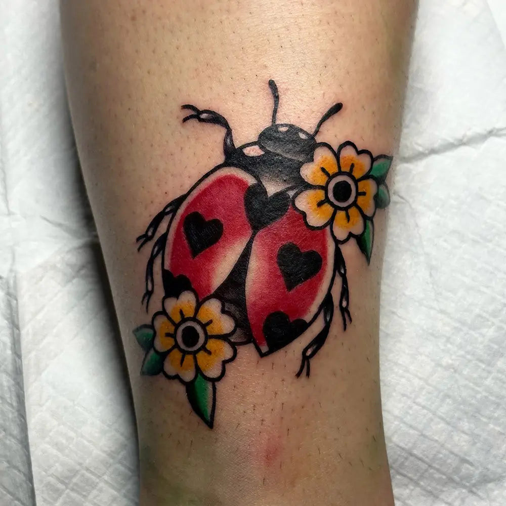 A ladybug tattoo framed by geometric shapes, offering a modern and balanced aesthetic, created by Ohigginsart