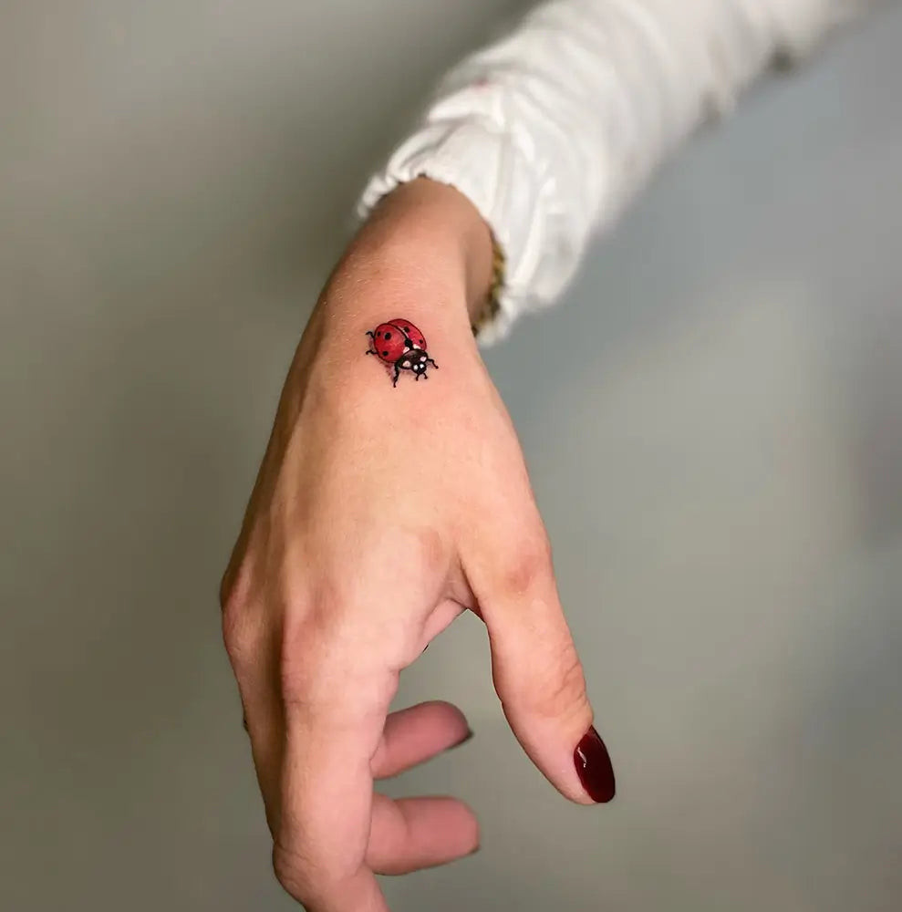 A vibrant and artistic ladybug tattoo, embodying personal expression and beauty, created by Madamtattooer