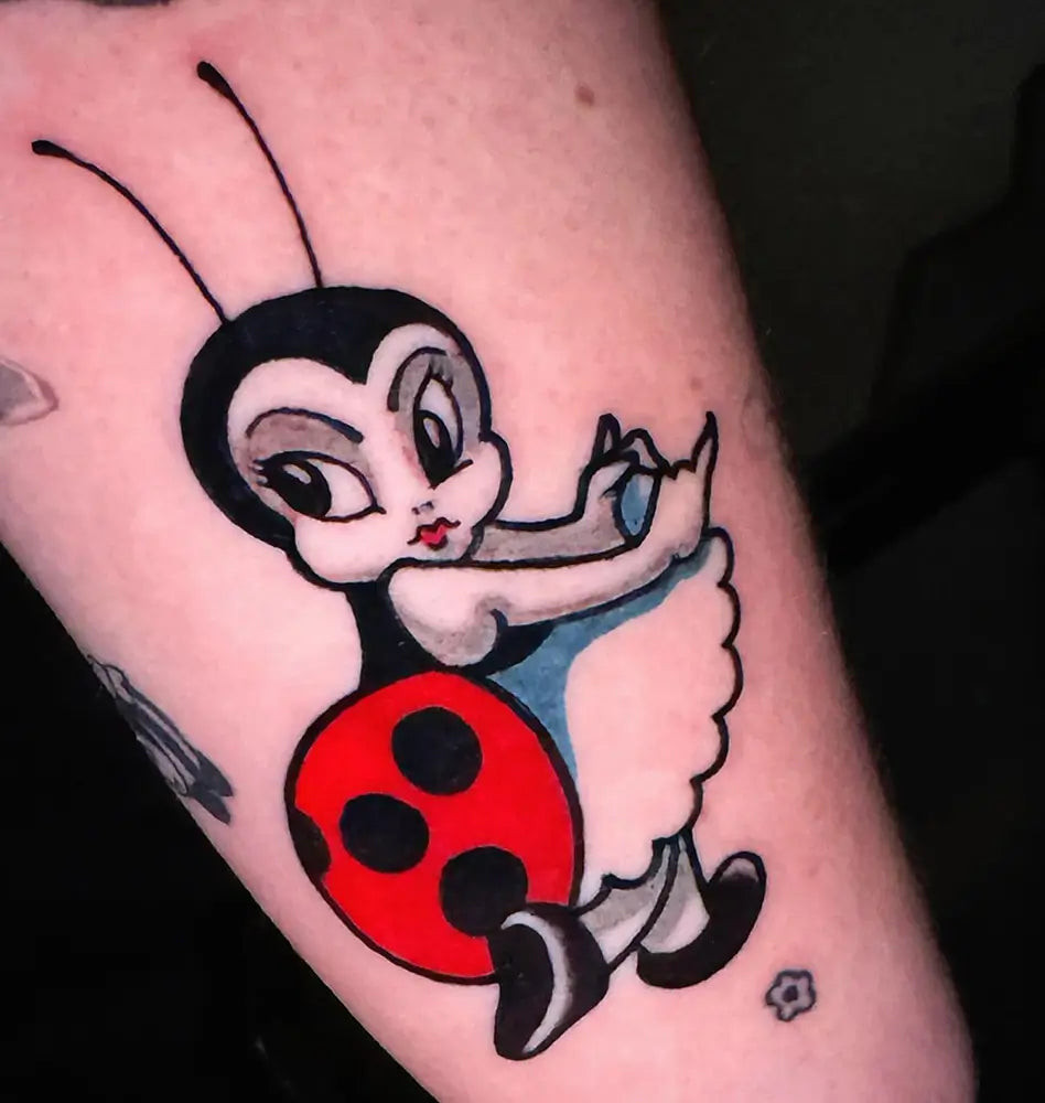 A ladybug tattoo with bold lines and vibrant colors, making a striking statement, created by Nikkibeetattoos