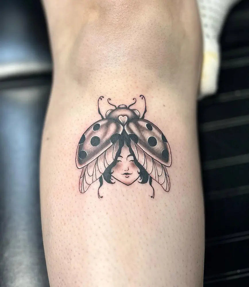 A detailed ladybug tattoo with floral elements, symbolizing new beginnings and renewal, created by Embrown.tattoo