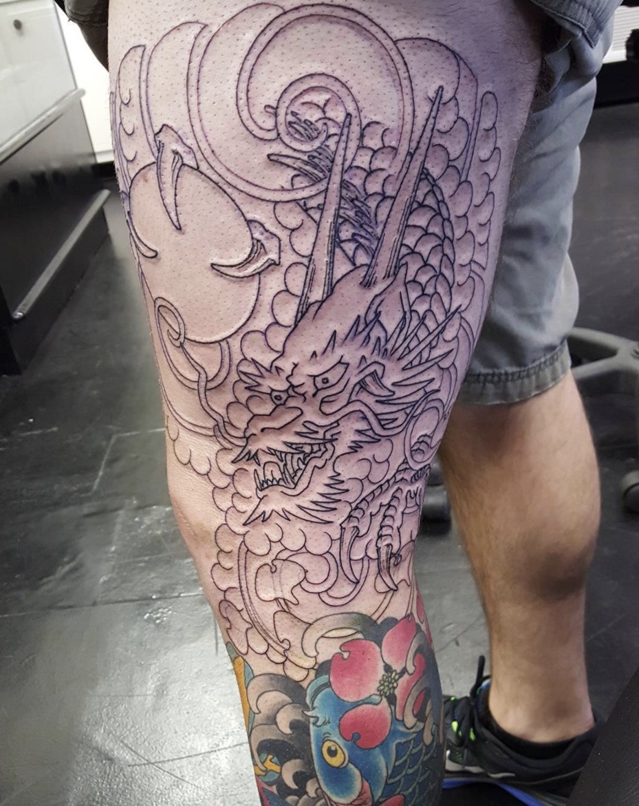 Dragon tattoo extending down thigh and leg