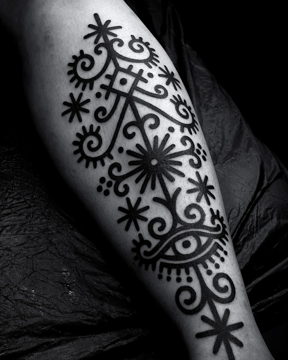 Geometric blackwork tattoo on arm, highlighting the bold and clean style of Lenn Black Lotus.