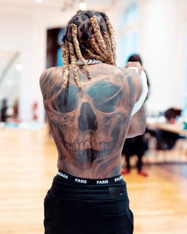 Lil Durk back tattoo, featuring a striking skull symbolizing resilience and mortality