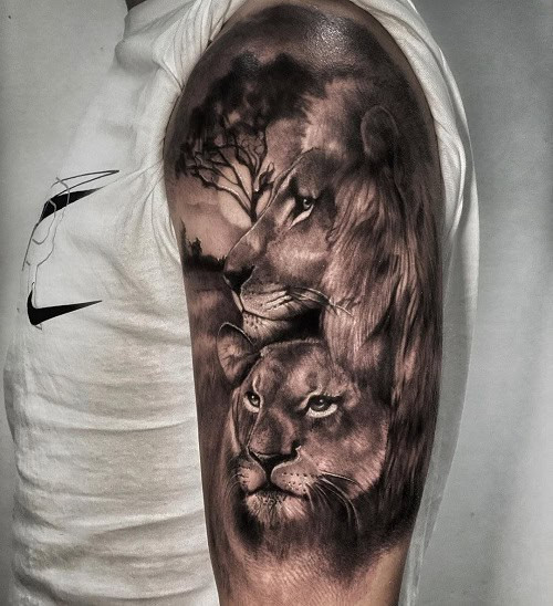 Lion and lioness with cubs tattoo on a man's arm, symbolizing family strength and protection.