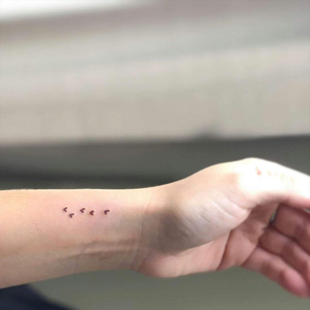 Multiple little hearts miscarriage tattoo on wrist.