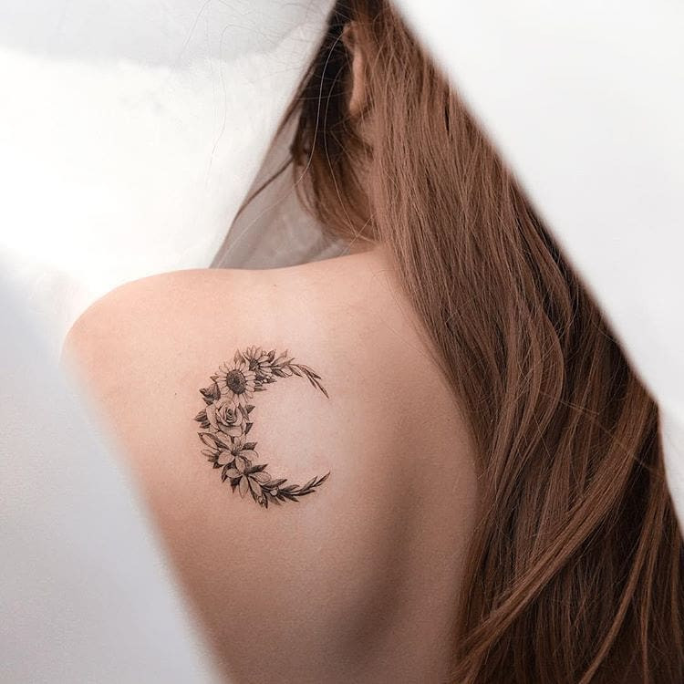 Floral crescent moon tattoo on forearm, celestial and botanical design