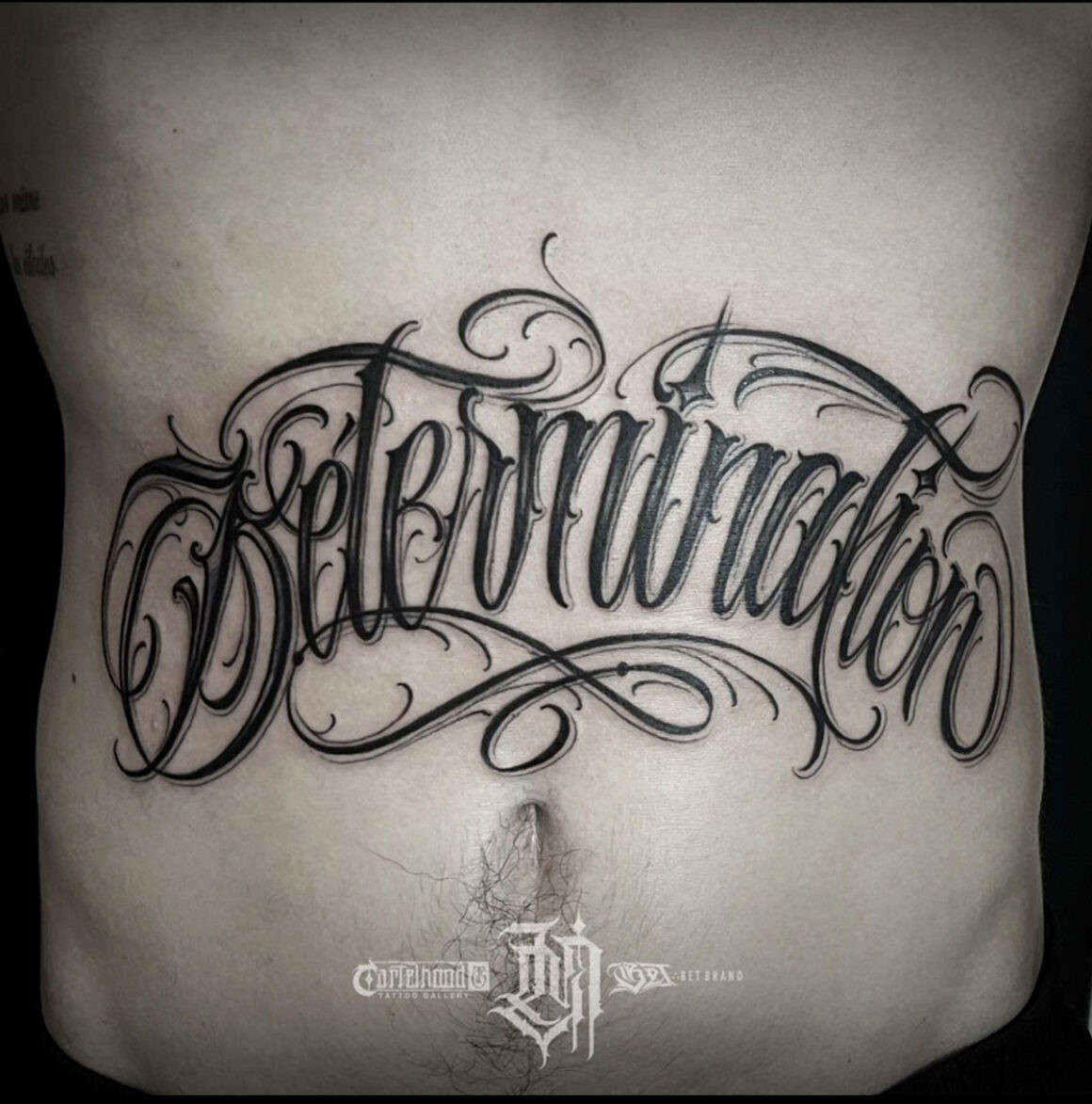 Elaborate Chicano lettering tattoo across the back by Lucho Morante