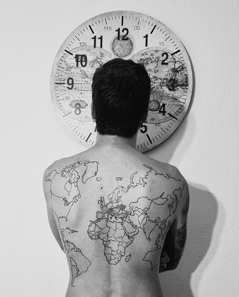 World map back tattoo for men symbolizing travel and exploration