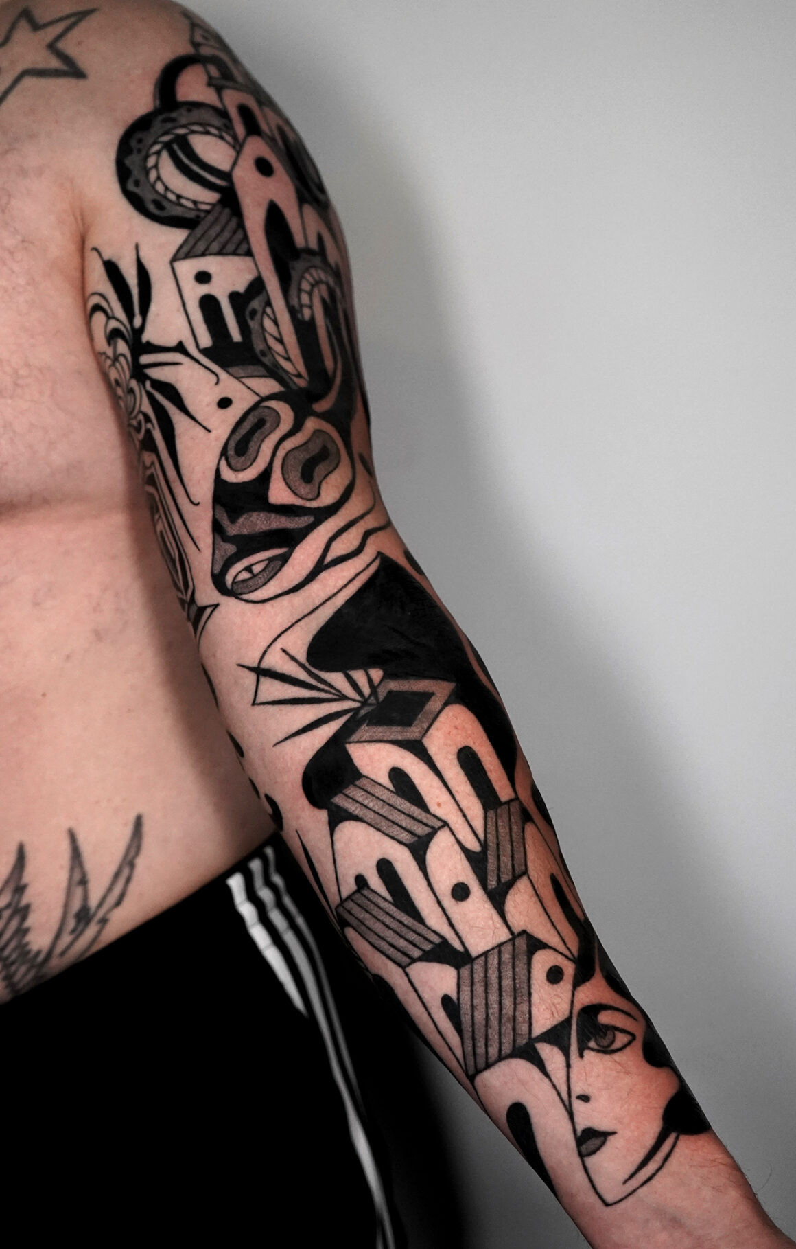 Full body shot of a surreal blackwork tattoo by Marco Gruschwitz, displaying the scale and impact of his art.