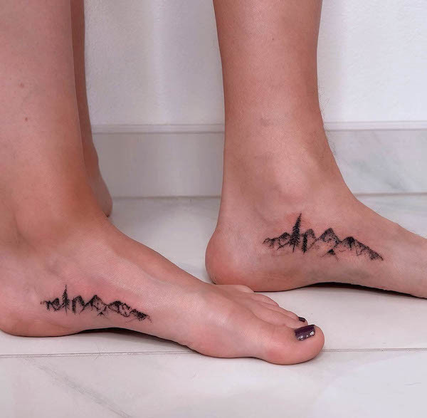 Matching mountain foot tattoos, representing determination, exploration, and striving for new heights, while staying grounded