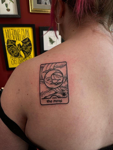 Matching Sun and Moon tarot card tattoos on different body parts, highlighting personal choice in matching designs.