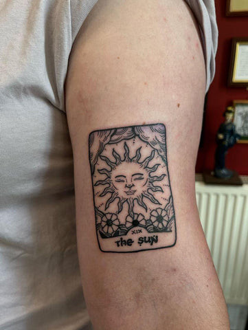 Matching Tarot card tattoos on arms for friends