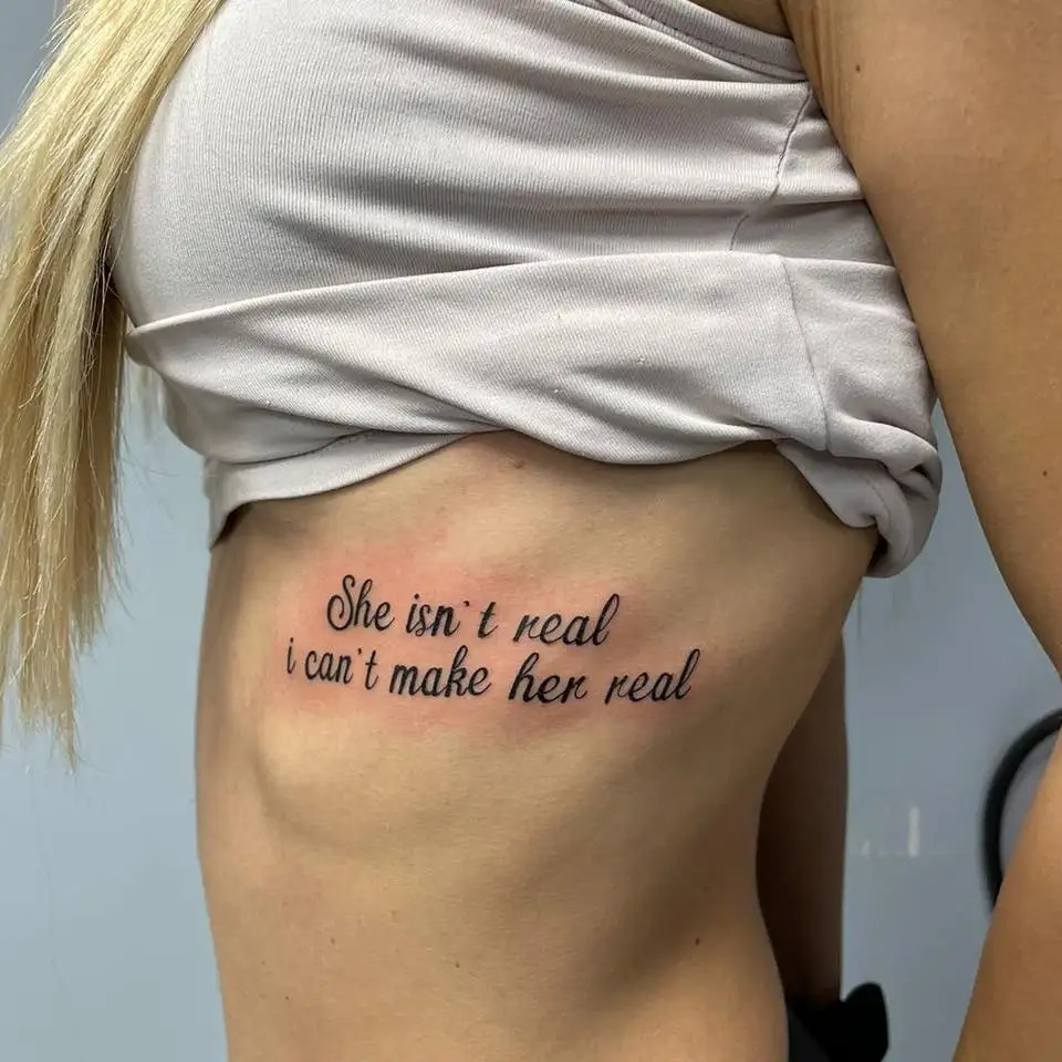 Inspirational quote tattoo along the ribs for women