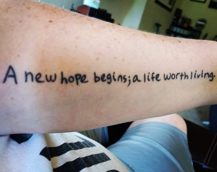 Tattoo across the inside of an arm with the words 