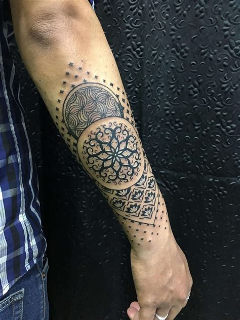 Minimalist black ink half sleeve tattoo with fine lines and subtle geometric shapes.