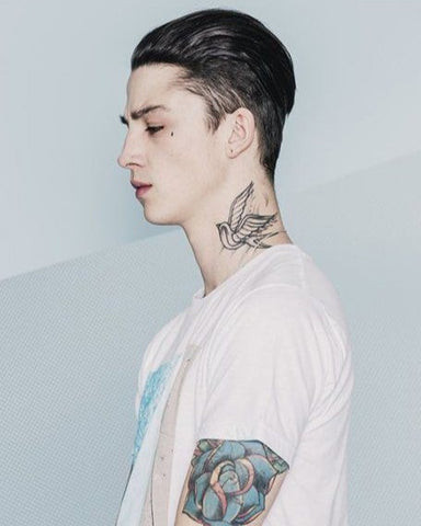 A man with a delicate feather side neck tattoo.