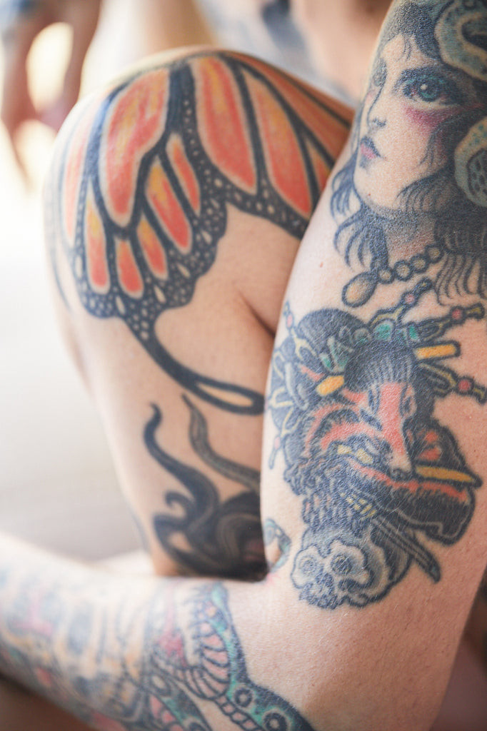 A detailed view of an older tattoo on a person's back, illustrating the fine lines and settled ink with subtle texture.